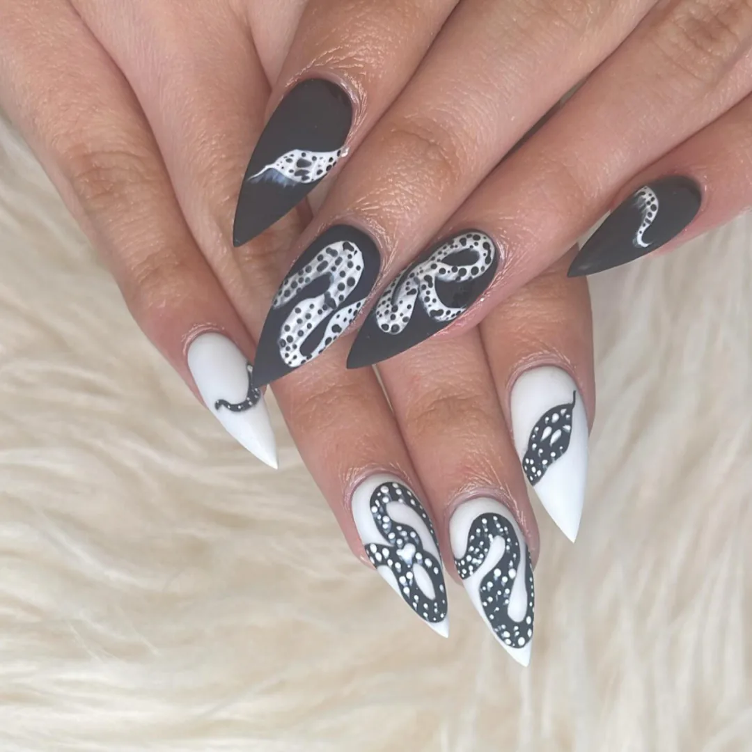 Black and white stiletto nails with hand-painted swirl details by Your Way Nail Spa