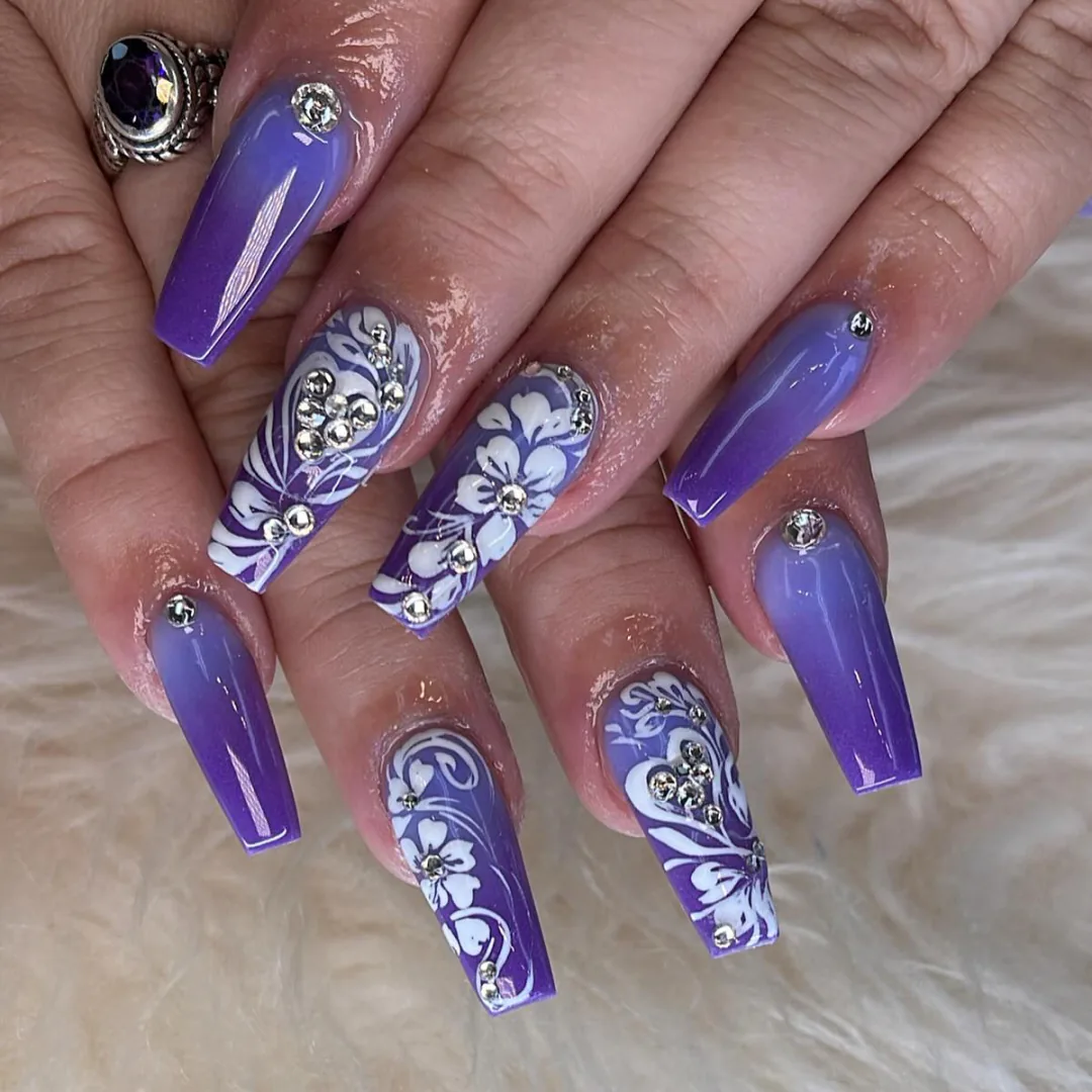 Violet coffin nails with white floral art and crystal details by Your Way Nail Spa