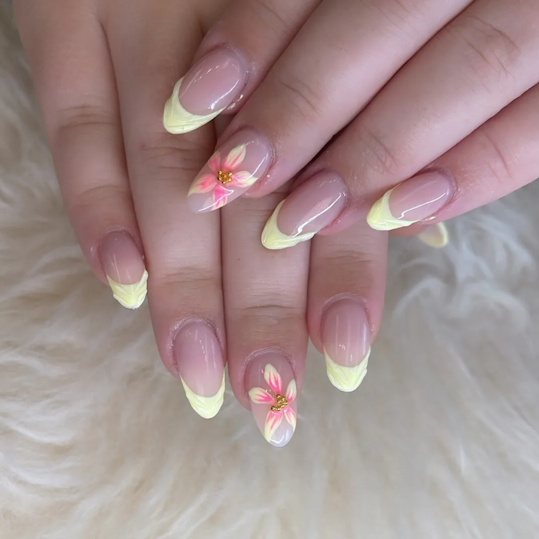 Natural almond nails with pale yellow French tips and pink flowers by Your Way Nail Spa