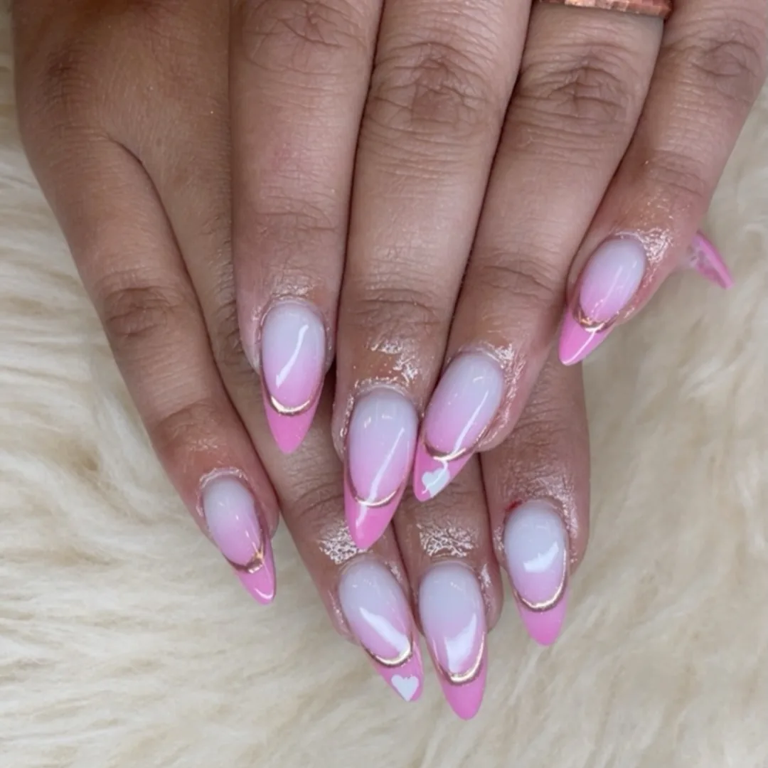 Pink almond French nails with gold curves and heart details by Your Way Nail Spa